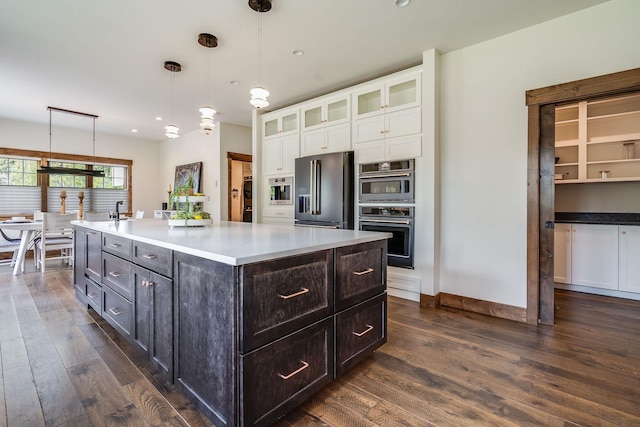 kitchen with stainless steel appliances, white cabinets, dark wood-type flooring, glass insert cabinets, and recessed lighting