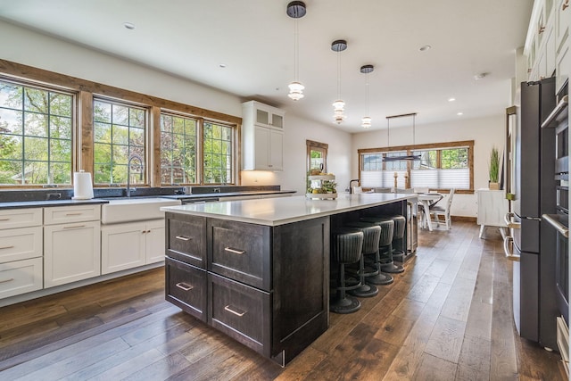 kitchen with a sink, white cabinetry, dark wood-type flooring, and recessed lighting