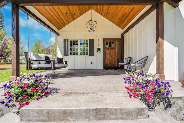 entrance to property featuring board and batten siding and a patio area