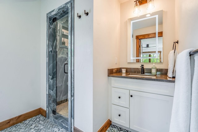 bathroom with a shower stall, vanity, and baseboards