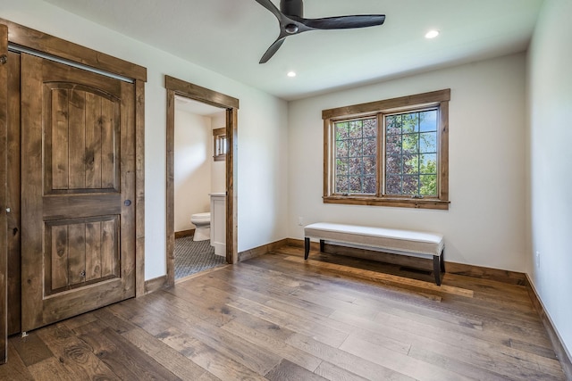 bedroom featuring dark wood-type flooring, baseboards, recessed lighting, ensuite bath, and ceiling fan