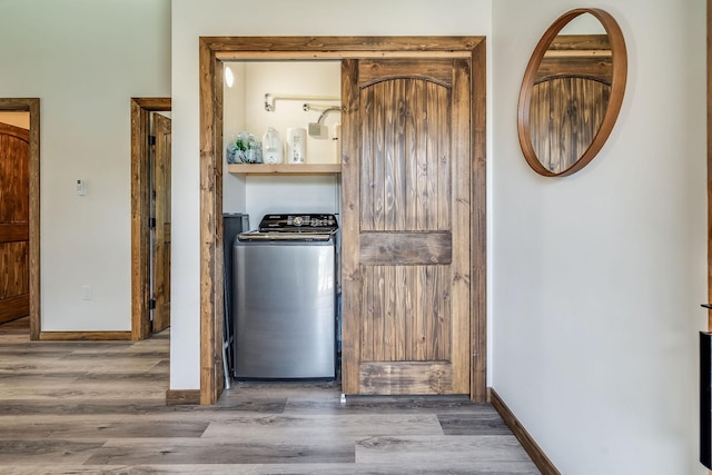 kitchen with washer / clothes dryer, wood finished floors, and baseboards