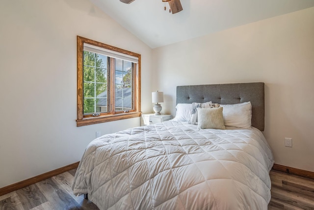 bedroom featuring baseboards, lofted ceiling, wood finished floors, and ceiling fan