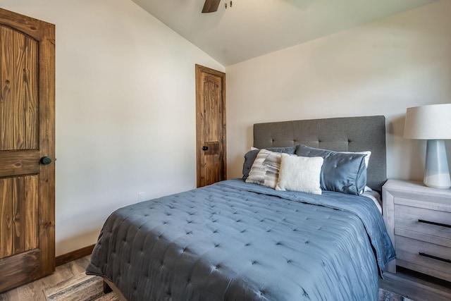bedroom with lofted ceiling, wood finished floors, baseboards, and ceiling fan