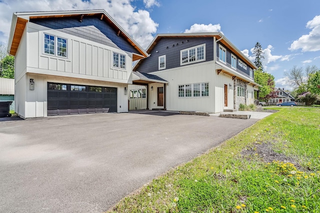 view of front of home with driveway, an attached garage, and board and batten siding