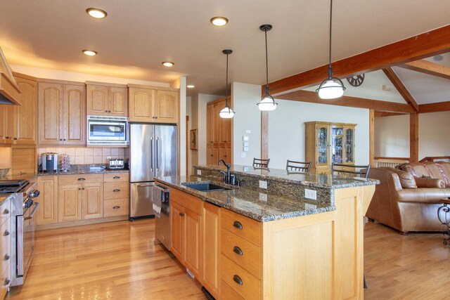 34520 Rocky Point Rd, Polson, MT 59860 - kitchen featuring appliances with stainless steel finishes, a sink, open floor plan, light wood-style floors, and light brown cabinets