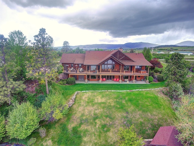 34520 Rocky Point Rd, Polson, MT 59860 - rear view of house with a yard, a patio area, and a mountain view