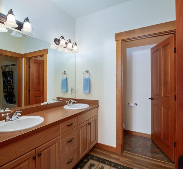 34520 Rocky Point Rd, Polson, MT 59860 - full bath with wood finished floors, double vanity, toilet, and baseboards