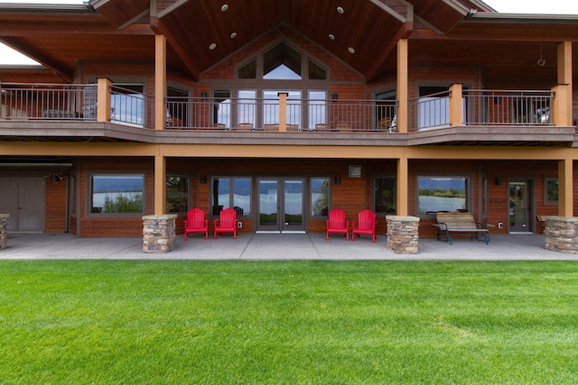 34520 Rocky Point Rd, Polson, MT 59860 - back of property featuring a balcony, a patio area, a lawn, and french doors