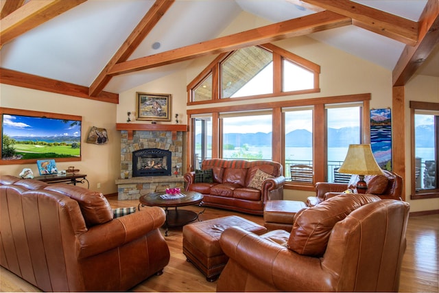 34520 Rocky Point Rd, Polson, MT 59860 - living area featuring high vaulted ceiling, beam ceiling, a stone fireplace, light wood finished floors, and healthy amount of natural light