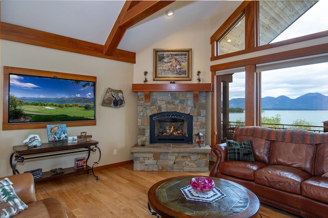 34520 Rocky Point Rd, Polson, MT 59860 - living area featuring a stone fireplace, wood finished floors, beam ceiling, baseboards, and high vaulted ceiling