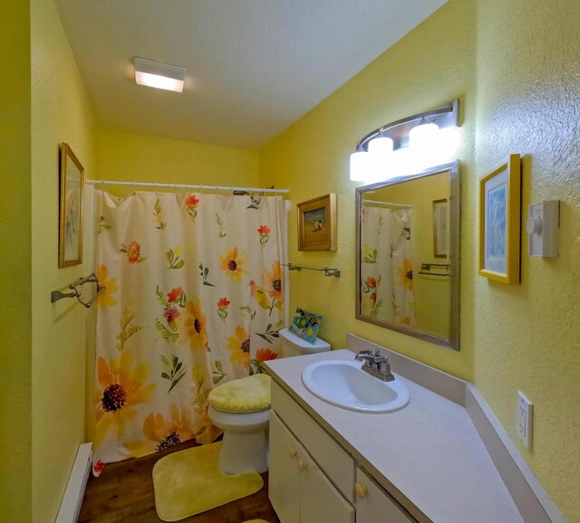 35881 Warbler Dr, Ronan, MT 59864 - full bath featuring baseboard heating, a textured wall, wood finished floors, vanity, and a shower with shower curtain
