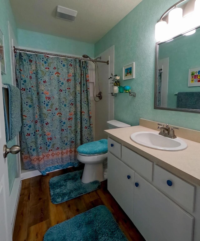 35881 Warbler Dr, Ronan, MT 59864 - bathroom featuring wood finished floors, a shower with curtain, toilet, vanity, and a textured wall