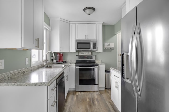 501 23rd Ave NE, Great Falls, MT 59404 - kitchen featuring appliances with stainless steel finishes, a sink, light wood-type flooring, and white cabinetry