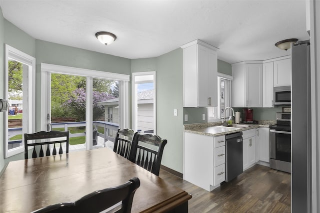 501 23rd Ave NE, Great Falls, MT 59404 - kitchen with appliances with stainless steel finishes, a sink, dark wood-type flooring, white cabinetry, and baseboards