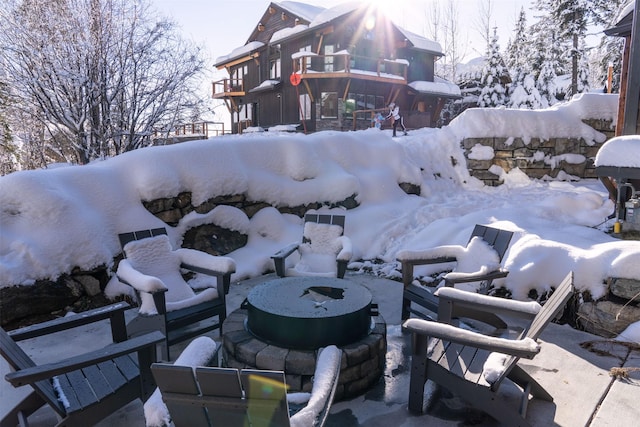 snow covered patio featuring a balcony