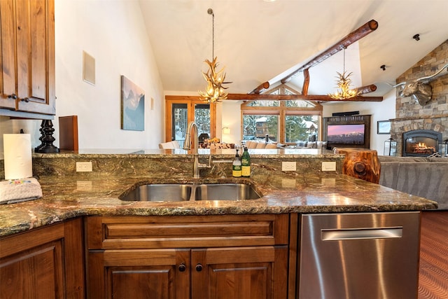 kitchen with a sink, open floor plan, stainless steel dishwasher, dark stone counters, and brown cabinets