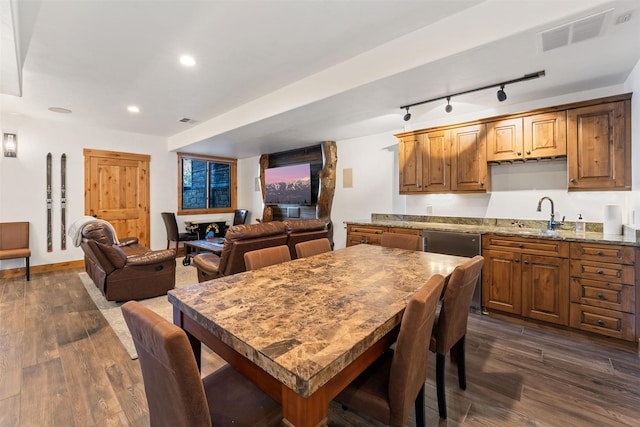 dining room featuring track lighting, dark wood-style flooring, recessed lighting, and baseboards