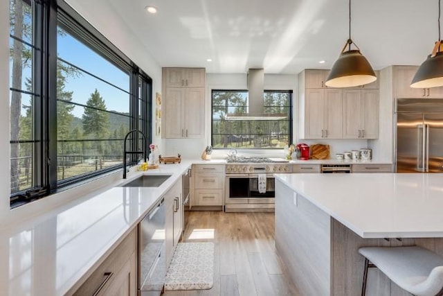 111 Blacktail Loop, Lakeside, MT 59922 - kitchen with premium appliances, plenty of natural light, light countertops, wall chimney range hood, and recessed lighting