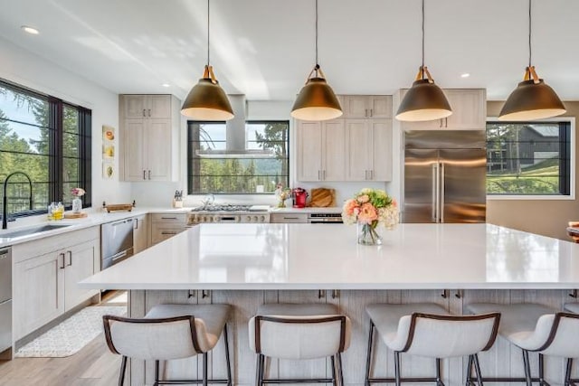 111 Blacktail Loop, Lakeside, MT 59922 - kitchen with appliances with stainless steel finishes, ventilation hood, a center island, light countertops, and recessed lighting
