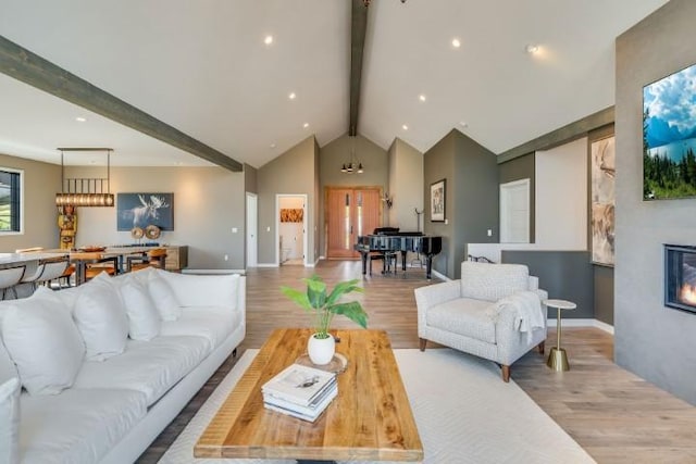 111 Blacktail Loop, Lakeside, MT 59922 - living room with beamed ceiling, wood finished floors, high vaulted ceiling, and a glass covered fireplace