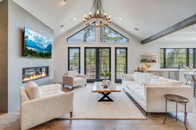 111 Blacktail Loop, Lakeside, MT 59922 - living room with a glass covered fireplace, a chandelier, wood finished floors, and high vaulted ceiling