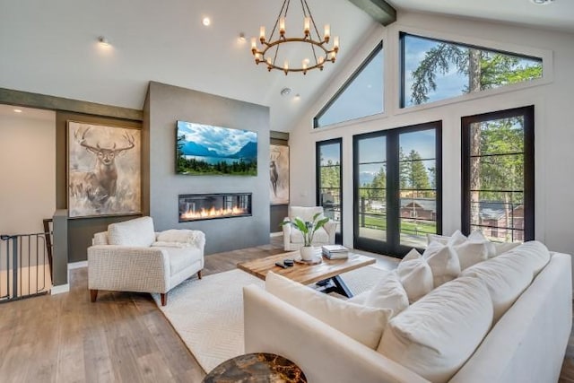 111 Blacktail Loop, Lakeside, MT 59922 - living area with a glass covered fireplace, a chandelier, beamed ceiling, hardwood / wood-style flooring, and high vaulted ceiling