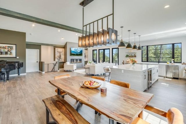 111 Blacktail Loop, Lakeside, MT 59922 - dining space featuring beverage cooler, light wood-style floors, recessed lighting, plenty of natural light, and beam ceiling