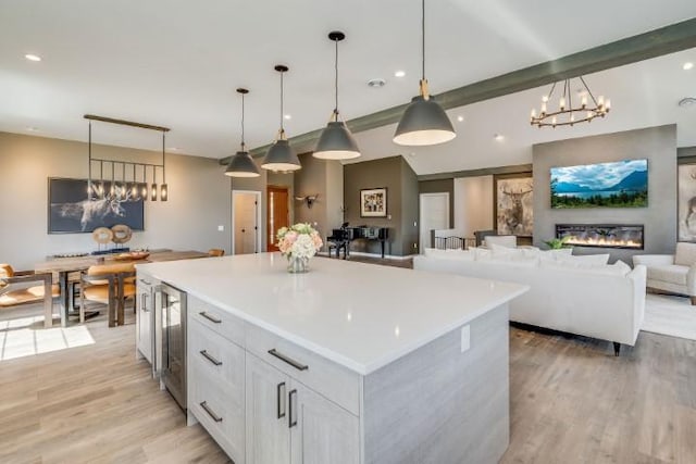 111 Blacktail Loop, Lakeside, MT 59922 - kitchen featuring beverage cooler, light wood-style floors, a center island, white cabinetry, and pendant lighting