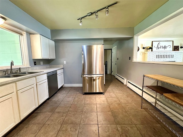 kitchen featuring freestanding refrigerator, dishwasher, a sink, light countertops, and rail lighting