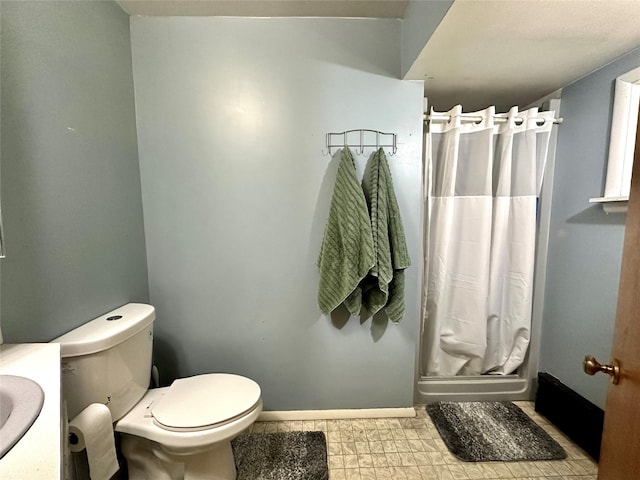 full bath with toilet, a shower stall, and baseboards