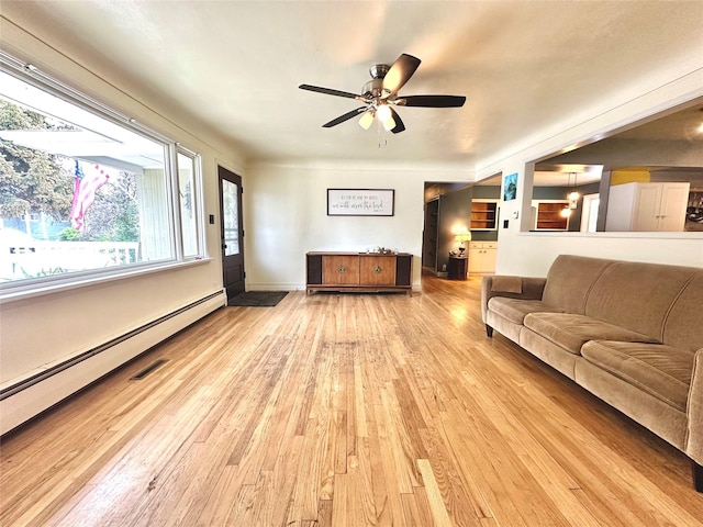 living room featuring wood-type flooring, ceiling fan, and a baseboard radiator