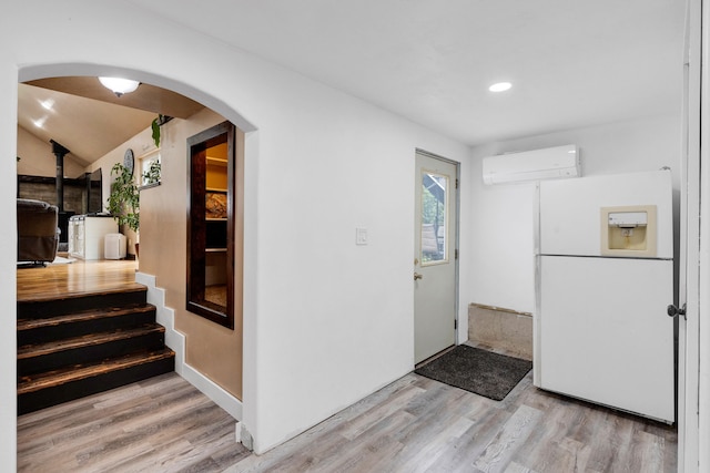 440 E 20th St, Hamilton, MT 59840 - kitchen featuring a wall mounted AC, white refrigerator with ice dispenser, light wood-style floors, arched walkways, and recessed lighting