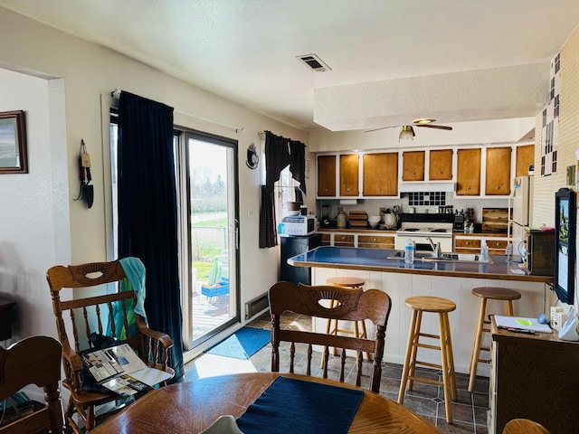 901 Birch Ave, Shelby, MT 59474 - kitchen featuring brown cabinets, a peninsula, backsplash, white appliances, and a sink