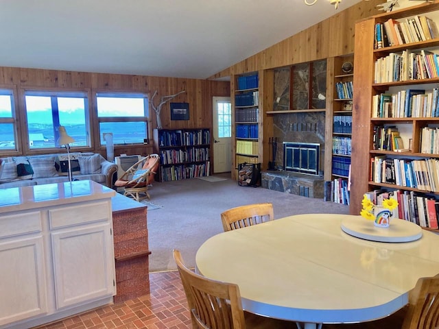 42984 Flathead View Dr, Polson, MT 59860 - dining room with wood walls, a fireplace, lofted ceiling, and carpet