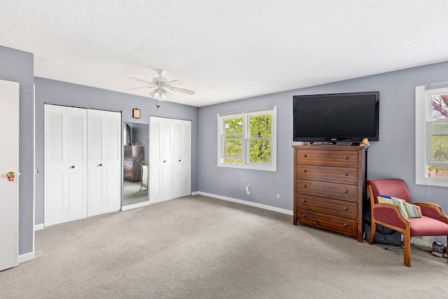 1200 32nd St S Unit 6, Great Falls, MT 59405 - bedroom with multiple closets, carpet floors, baseboards, a textured ceiling, and a ceiling fan
