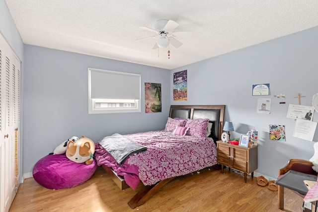 1200 32nd St S Unit 6, Great Falls, MT 59405 - bedroom with wood finished floors, a textured ceiling, a closet, ceiling fan, and baseboards