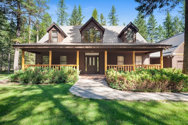 view of front of home featuring a porch, a front yard, and metal roof