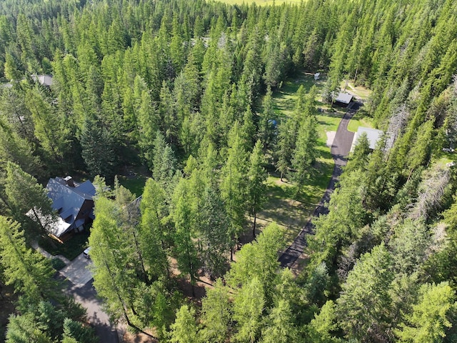 aerial view of property and surrounding area featuring a forest