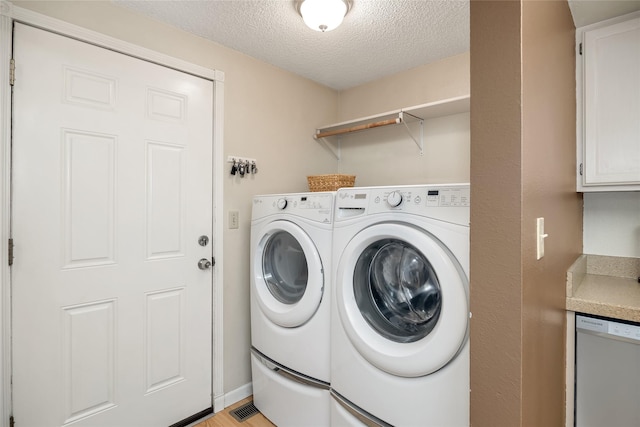 laundry room featuring a textured ceiling and independent washer and dryer