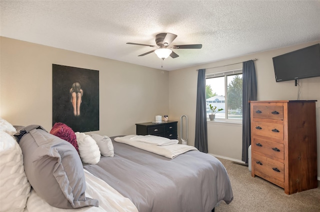 bedroom featuring a textured ceiling, light carpet, and ceiling fan