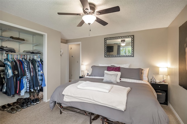 bedroom with a closet, a textured ceiling, carpet flooring, a ceiling fan, and baseboards