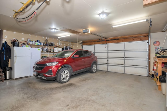 garage featuring freestanding refrigerator and a garage door opener