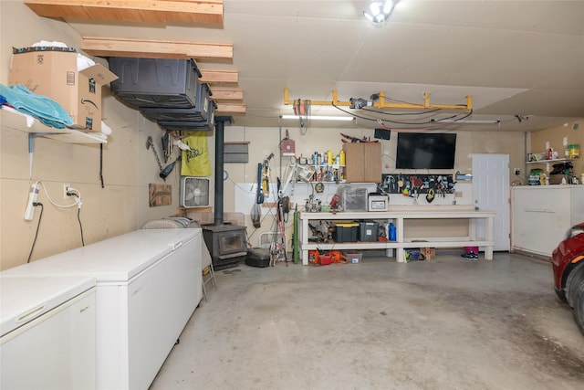 garage featuring a workshop area, a wood stove, and fridge