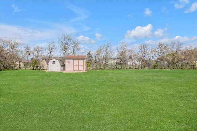 view of green lawn featuring a storage shed and an outdoor structure