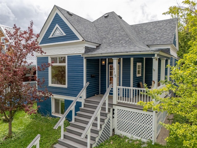 view of front of property featuring a shingled roof, a porch, and stairs