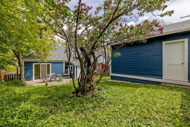 back of property with a patio area and a shingled roof