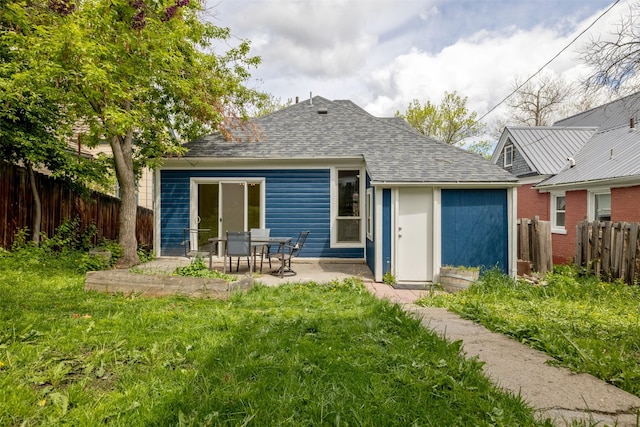 back of house with a shingled roof and a patio area
