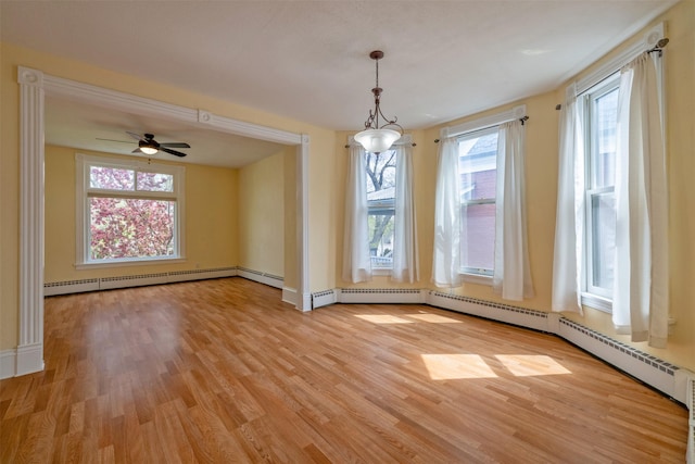 unfurnished dining area with light wood finished floors, baseboards, ceiling fan, and a baseboard heating unit