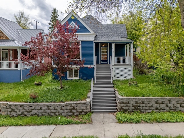 view of front of home with stairway, covered porch, and a shingled roof